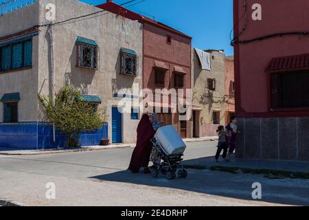 El Jadida, Maroc - 16 avril 2016 : scène de rue dans un quartier de la ville d'El Jadida, avec deux femmes qui parlent et des enfants qui jouent. Banque D'Images