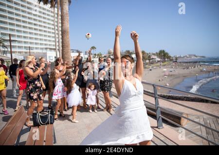 Lancement du bouquet de mariage, la jeune mariée jette les fleurs au groupe de femmes derrière elle. Moment de soie de bouquet. Banque D'Images