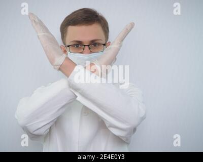 Portrait d'un jeune homme d'apparence européenne dans un manteau médical blanc. Un médecin portant un masque médical Banque D'Images