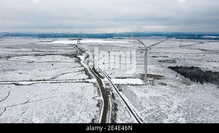 Parc éolien de Whitelee, Eaglesham, Écosse, Royaume-Uni. 15 janvier 2021. Photo : les gens qui marchent et font du jogging sur les landes enneigées de la ferme éolienne de Whitelee font leur exercice quotidien alors que l'Écosse est toujours en phase 4 verrouillée en raison de la pandémie du coronavirus (COVID-19). Parc éolien de Whitelee vu sous un tapis de neige, qui est encore couché sur le sol en raison de son emplacement sur le sol supérieur. Il est populaire avec les gens qui prennent leur exercice de verrouillage quotidien. Crédit : Colin Fisher Banque D'Images