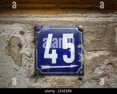 Numéro 45, le nombre de maisons, appartements, rues. Le numéro blanc sur une plaque métallique bleue, le numéro de maison quarante-cinq (45) sur un mur rugueux. Banque D'Images