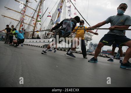 Un certain nombre de membres de l'équipage du KRI Dewaruci, portant un masque tout en faisant un remorqueur de guerre à la jetée de Kolinlamil (Commandement maritime militaire), Tanjung Priok, nord de Jakarta, vendredi (22/1/2021). L'arrivée du légendaire navire KRI (cuirassé de la République d'Indonésie) Dewaruci appartenant à la Marine indonésienne qui a dans le monde entier, afin de soutenir la commémoration de la journée Dharma Samudera. KRI Dewaruci a contribué à promouvoir le tourisme indonésien aux yeux de la communauté internationale. Après cet événement, KRI Dewaruci se tiendra à Surabaya, Java-est. (Photo de Kuncoro Widyo Rumpoko/Pacific Press/ Banque D'Images