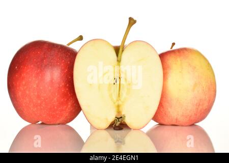 Deux pommes entières et une moitié entières, en gros plan, rouge savoureuses, mûres, juteuses, sur fond blanc. Banque D'Images