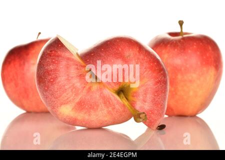 Deux moitiés d'une pomme, au foyer, pommes rouges délicieuses mûres juteuses, sur fond blanc. Deux pommes entières à l'arrière-plan. Banque D'Images