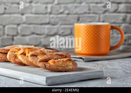 Petits gâteaux faits maison avec fromage cottage et une tasse de thé sur fond gris. Cuisson maison Banque D'Images