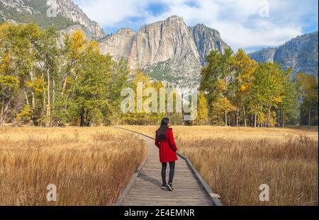 Femme en manteau rouge avec paysage automnal au parc national de Yosemite, Californie, États-Unis. Banque D'Images