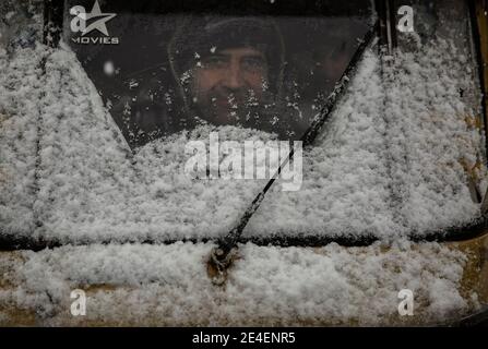 Srinagar, Cachemire sous contrôle indien. 23 janvier 2021. Un pilote de pousse-pousse automatique regarde pendant qu'il roule au milieu des chutes de neige dans la ville de Srinagar, la capitale estivale du Cachemire contrôlé par l'Inde, le 23 janvier 2021. Samedi, une chute de neige a frappé le Cachemire contrôlé par l'Inde. Crédit : Javed Dar/Xinhua/Alay Live News Banque D'Images