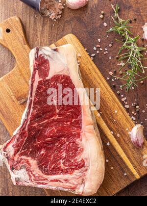 Steak de bœuf de sashi frais cru au romarin, sel de l'himalaya, ail et grains de poivre noir, prêts à être cuits Banque D'Images