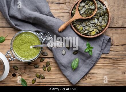 En-cas sain riche en minéraux, beurre de graines de citrouille fraîchement préparé dans un pot en verre sur fond de bois Banque D'Images