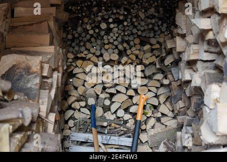 Abri de jardin intérieur avec bois empilé et haches Banque D'Images