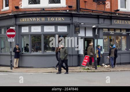 Greenwich taverne bienvenue à emporter clients à l'entrée, homme ayant une pinte de Guinness debout à l'extérieur de Londres Banque D'Images