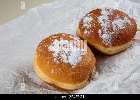 Frais cuits et garnis de sucre en poudre de beignets allemands - Berliner ou Krapfen - sur table blanche. Banque D'Images