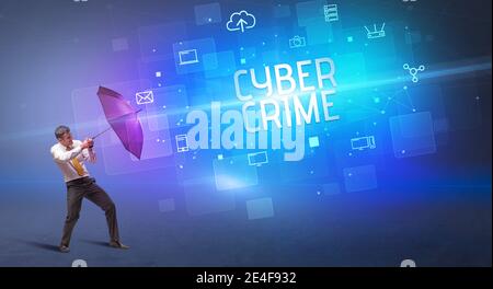 Homme d'affaires se défendant avec le parapluie de la cyber-attaque et de L'inscription DE LA CYBER-CRIMINALITÉ, concept de sécurité en ligne Banque D'Images