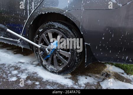 Concept de lavage de voiture extérieur, lavage d'une voiture avec une brosse en mousse Banque D'Images