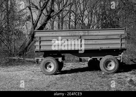 Photo en niveaux de gris d'un ancien chariot tracteur-remorque rural dans un champ Banque D'Images