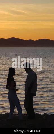 Silhouette de femme et d'homme debout au coucher du soleil. Illustration de Vecteur