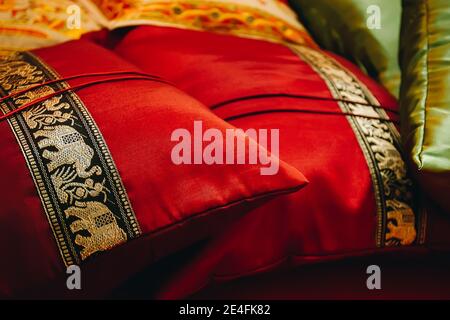 Gros plan sur les oreillers en satin brodé d'éléphant rouge sur le canapé, détails intérieurs indiens Banque D'Images