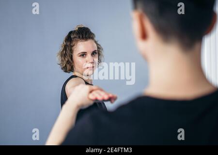 Une femme instructeur de taekwondo organise une séance d'entraînement personnelle pour une jeune femme à la salle de gym. Fille mastering nouveau taekwondo se déplace pendant la classe avec l'entraîneur. Exe Banque D'Images