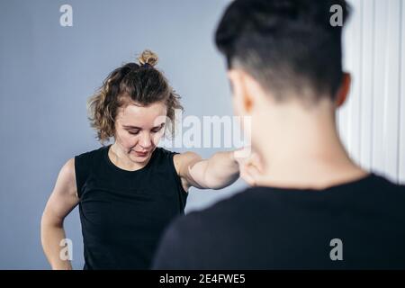 Une femme instructeur de taekwondo organise une séance d'entraînement personnelle pour une jeune femme à la salle de gym. Fille mastering nouveau taekwondo se déplace pendant la classe avec l'entraîneur. Exe Banque D'Images