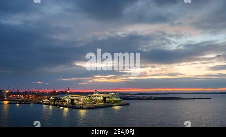 Lever du soleil tôt le matin sur la côte Baltique d'Helsinki Finlande avec le port du bateau de croisière en vue de la mer. Banque D'Images