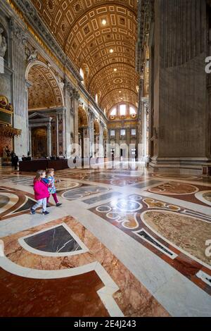 BASILIQUE SAINT-PIERRE, CITÉ DU VATICAN - vue de l'intérieur pendant l'éclusage du coronavirus Covid-19. Deux jeunes filles touristes marchant autour de l'immense église Banque D'Images