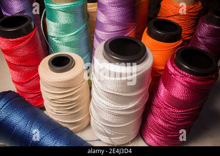 Plusieurs cornets colorés avec différentes couleurs de fil telles que : blanc, rouge, violet, rose, vert, orange, bleu, jaune Banque D'Images