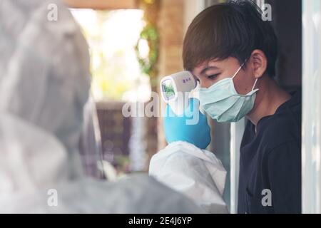 Une infirmière proactive de la santé à domicile utilise le scanner de contrôle de la mesure de la température Surveiller en main au Taiand local Banque D'Images