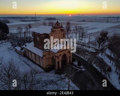 Soleil levant au-dessus de la plaine enneigée et du sanctuaire de Varalino di Galliate, Novara, Piémont, Italie Banque D'Images