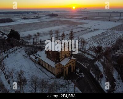 Soleil levant au-dessus de la plaine enneigée et du sanctuaire de Varalino di Galliate, Novara, Piémont, Italie Banque D'Images