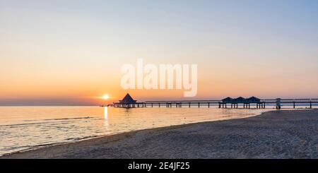 Allemagne, Mecklembourg-Poméranie occidentale, Heringsdorf, plage côtière de sable au lever du soleil avec l'embarcadère d'Heringsdorf en arrière-plan Banque D'Images