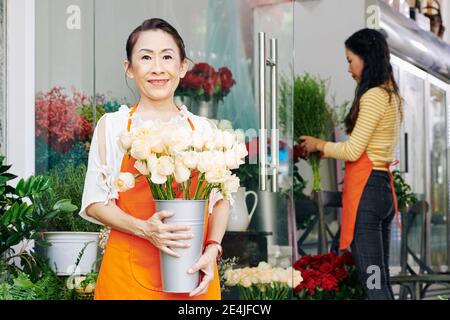 Fleuriste senior avec roses Banque D'Images