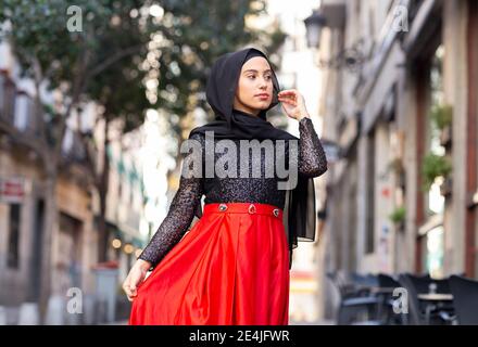 Portrait de la jeune femme portant le hijab noir debout à l'extérieur Banque D'Images