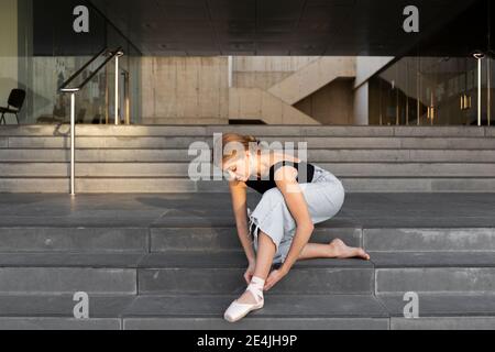 Ballerine nouant des patins de ballet sur les marches Banque D'Images