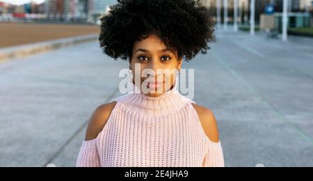 Belle femme aux cheveux afro debout dans la rue Banque D'Images