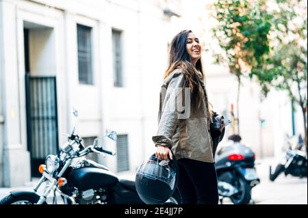 Motard femme portant un casque à moto dans la rue de la ville Banque D'Images