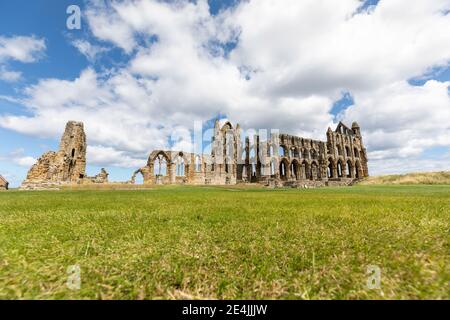 Abbaye de Whitby sur un paysage herbeux contre le ciel nuageux pendant la journée ensoleillée, Yorkshire, Royaume-Uni Banque D'Images