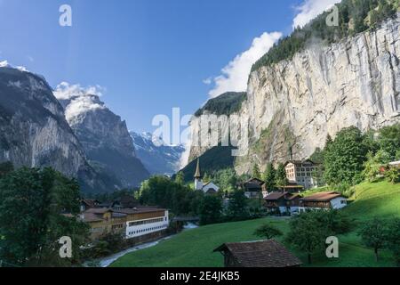 Vue du matin sur la ville de Lauterbrunnen dans l'Oberland bernois, Suisse. La ville se trouve sous les imposantes falaises et la chute de Staubbach. Banque D'Images