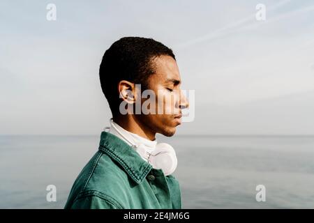 Homme avec les yeux fermés jour rêvant par la mer Banque D'Images