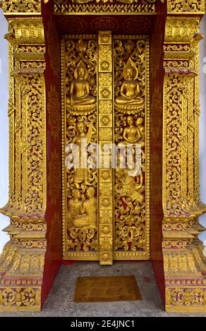 Portail d'entrée avec sculptures dorées, créatures mythologiques et scènes de la vie de Bouddha, temple Wat Nong Sikhounmuang, Luang Banque D'Images