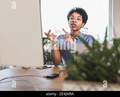 Femme assise devant l'ordinateur, ayant la vidéoconférence Banque D'Images