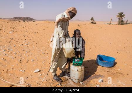 Des garçons locaux tirent l'eau d'un puits dans le désert, Sahara entre Ounianga Kebir et Faya, Tchad Banque D'Images