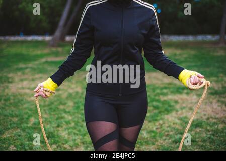 Photo en extérieur d'une femme déterminée sautant à l'extérieur dans la nature. Banque D'Images