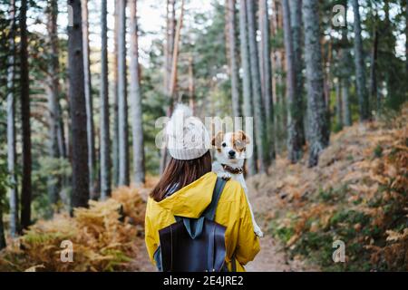 Femme transportant un chien en forêt Banque D'Images