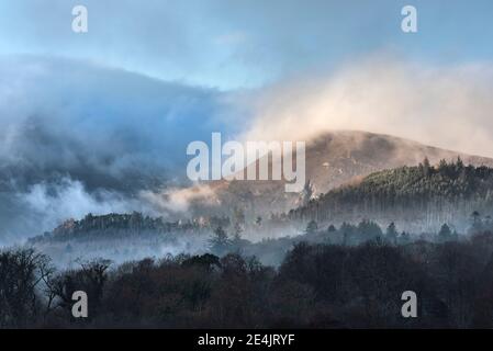 Image de paysage épique regardant à travers Derwentwater dans Lake District vers Catbells a enneigé la montagne avec un épais brouillard qui se balade dans la vallée Banque D'Images