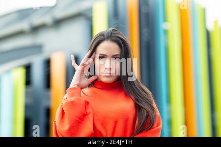 Portrait de la belle brunette debout à l'extérieur avec la main dans les cheveux Banque D'Images