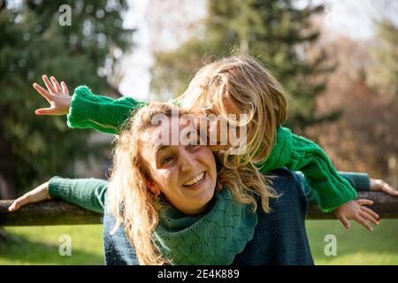 Une mère souriante, une fille qui se tient debout au parc