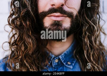 Jeune homme avec une barbe et de longs cheveux bruns Banque D'Images