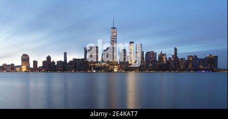 USA, New York, New York City, Lower Manhattan avec un World Trade Center illuminé à l'aube vu de l'autre côté de la rivière Banque D'Images