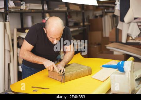 le classeur de livre restaure l'ancien livre dans l'atelier d'artisanat Banque D'Images