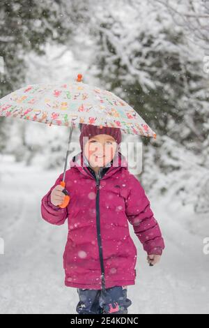 Kidderminster, Royaume-Uni. 24 janvier 2021. Météo au Royaume-Uni : les chutes de neige matinales surprennent les résidents du Worcestershire avec de fortes chutes de neige provoquant une couverture blanche hivernale entre 8h et 10H. Phoebe aux joues roses, bien enveloppée, est sortie marcher dans la neige, vraiment profiter du pays des merveilles de l'hiver. Crédit : Lee Hudson/Alamy Live News Banque D'Images